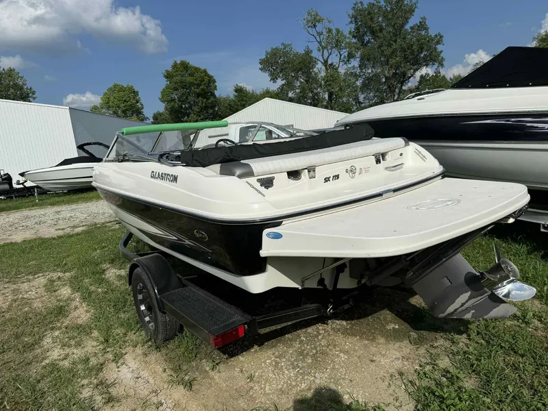 Slide: The Image of 2006 Glastron SX 175 boat on trailer, parked outdoors near other boats. - 3