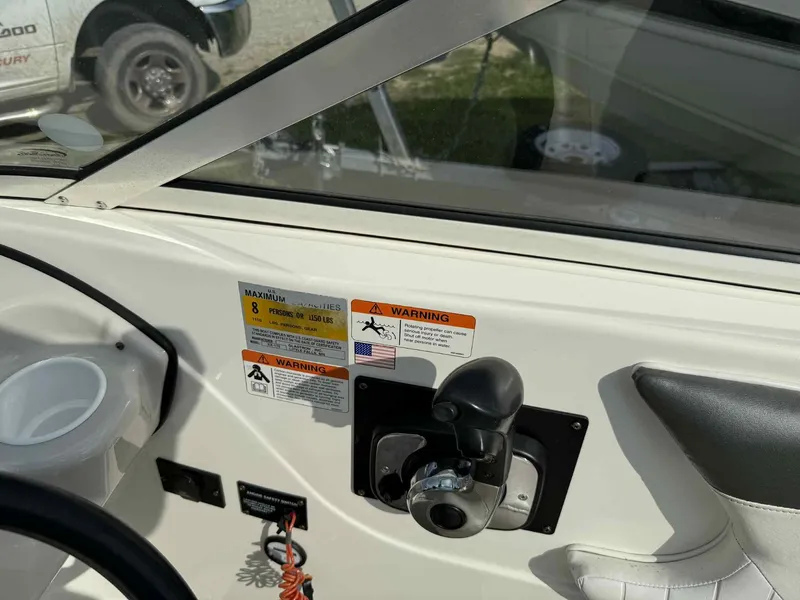 Slide: The Image of 2006 Glastron SX 175 boat interior with capacity warning label and control lever. - 6