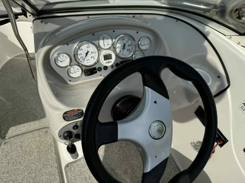 Slide: The Image of 2006 Glastron SX 175 boat dashboard with steering wheel and gauges. - 7