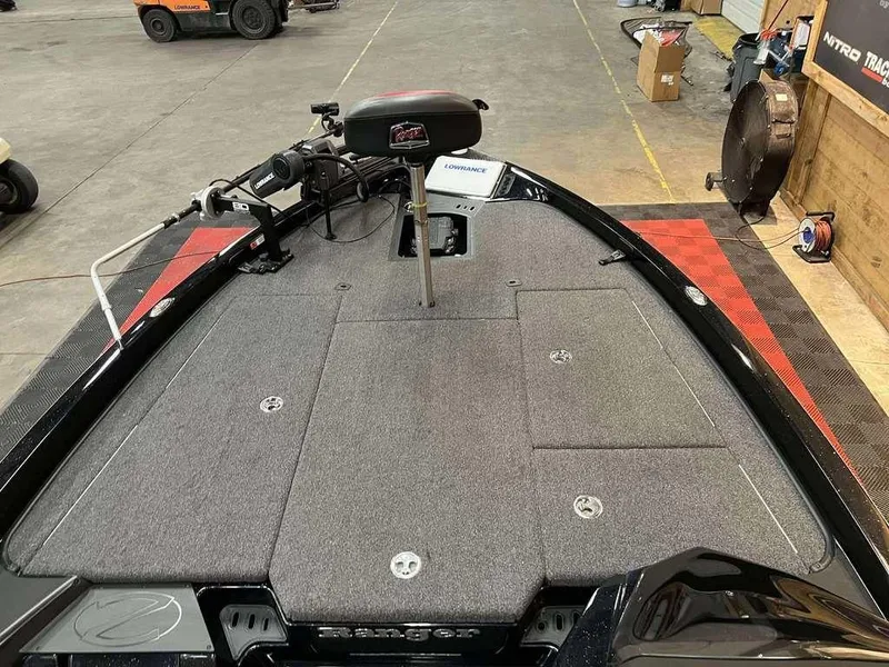Slide: The Image of 2022 Ranger Z519 boat deck with trolling motor and storage compartments in a workshop setting. - 6