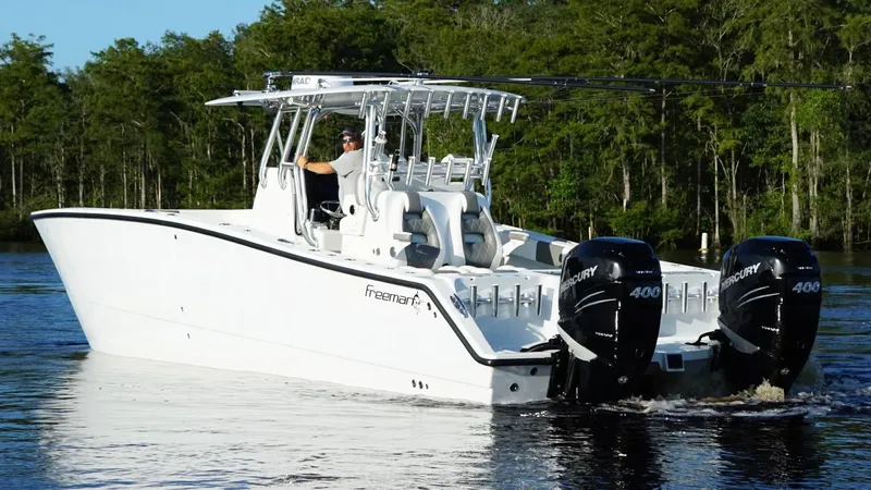 Slide: The Image of 2023 Freeman 34VH boat with dual Mercury 400 engines cruising on a lake. - 12