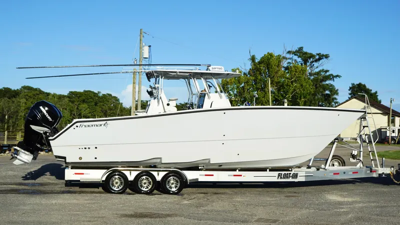 Slide: The Image of 2023 Freeman 34VH boat on trailer, side view, outdoors. - 13