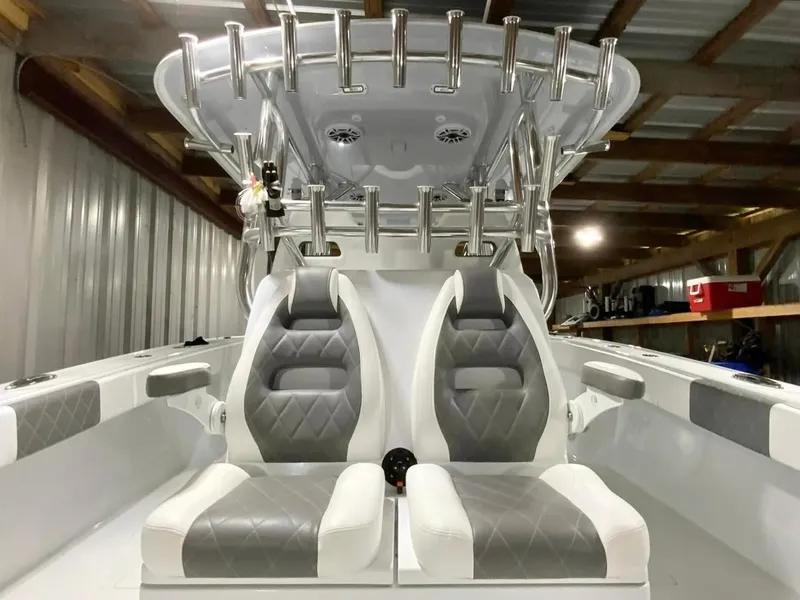 Slide: The Image of 2023 Freeman 34VH boat interior with dual gray and white seats, rod holders, and storage. - 15
