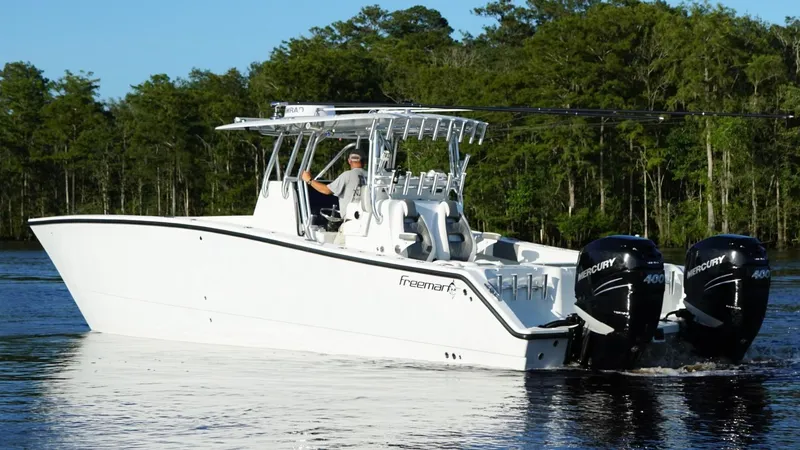 Slide: The Image of 2023 Freeman 34VH boat with dual Mercury engines on a serene lake. - 5