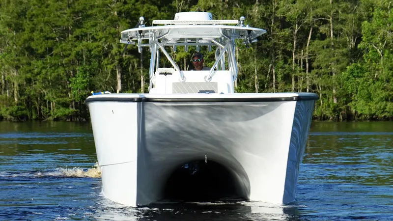 Slide: The Image of 2023 Freeman 34VH boat cruising on a calm river with lush green forest backdrop. - 6