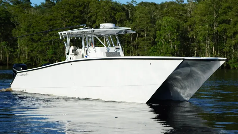 Slide: The Image of 2023 Freeman 34VH boat cruising on a calm lake with forested background. - 8