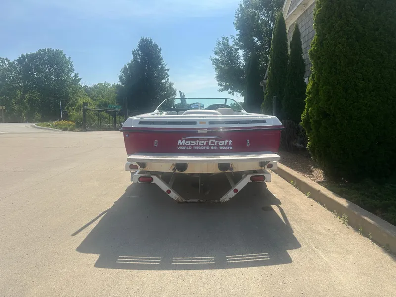 Slide: The Image of 1993 MasterCraft ProStar 190 boat parked on a sunny street, rear view. - 1