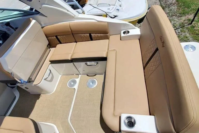 Slide: The Image of 2017 Sea Ray 260 Sundancer boat interior with tan seating and cup holders. - 8