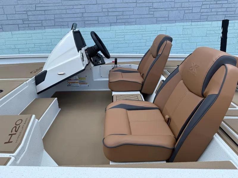 Slide: The Image of 2026 Xpress H20 Bass boat interior with tan seats and steering console. - 5