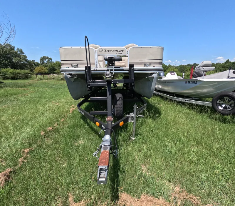 The Image of 2011 Lowe Suncruiser SF214 pontoon boat on trailer, parked on grassy field. - 1