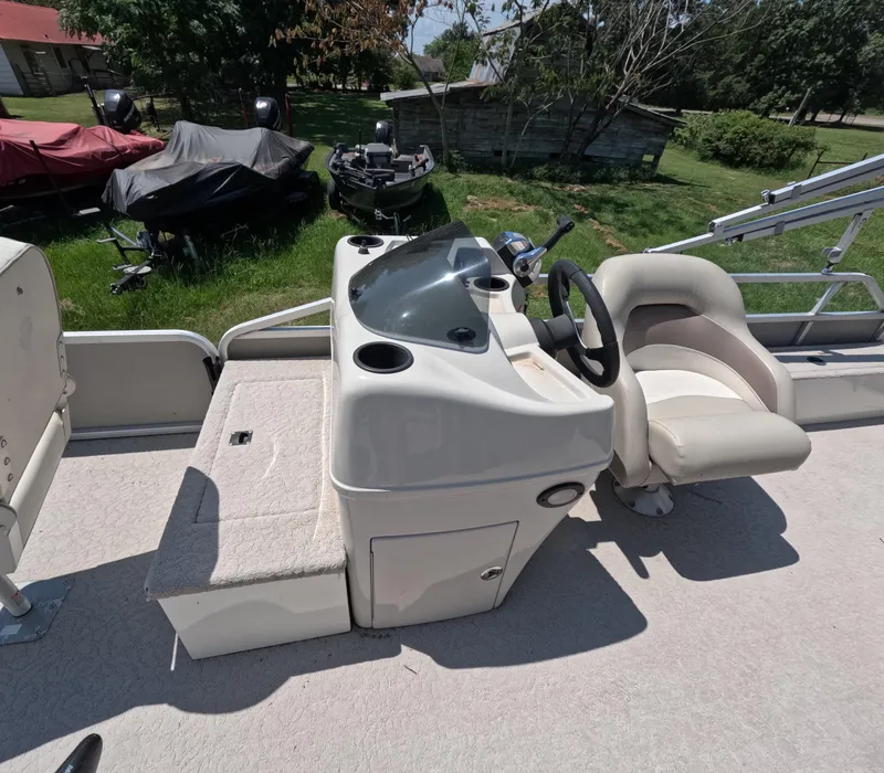 Slide: The Image of 2011 Lowe Suncruiser SF214 boat interior with steering console and seating. - 12