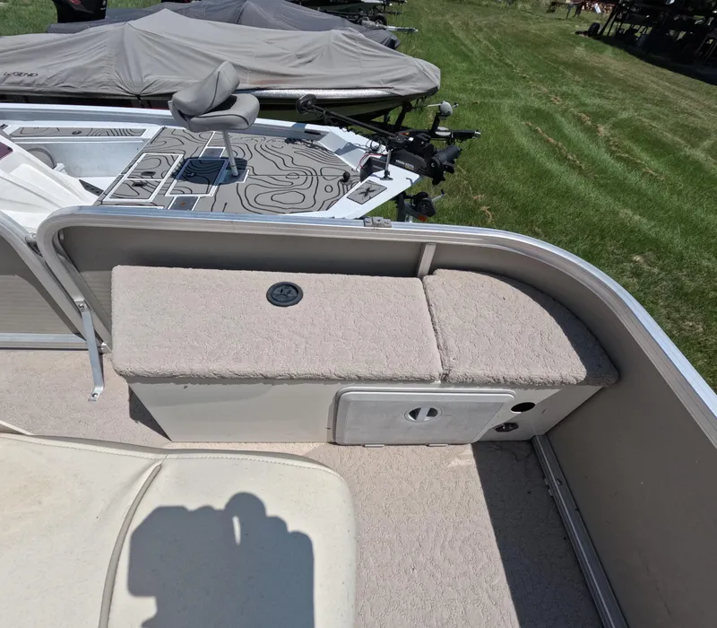 Slide: The Image of 2011 Lowe Suncruiser SF214 boat interior with cushioned seating and storage compartment. - 13