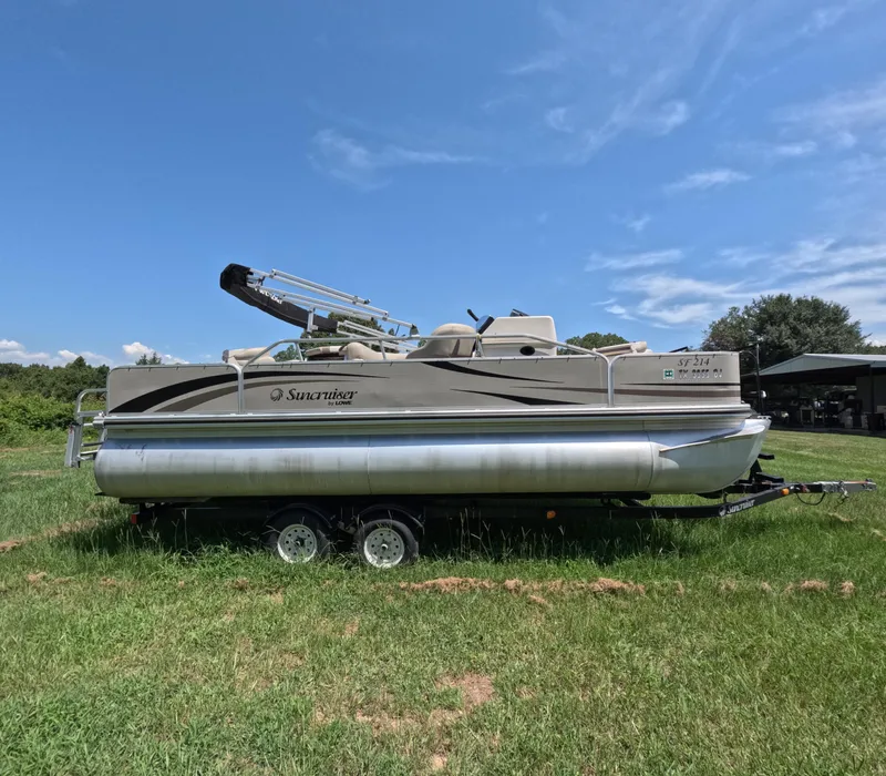 Slide: The Image of 2011 Lowe Suncruiser SF214 pontoon boat on trailer in grassy field. - 2