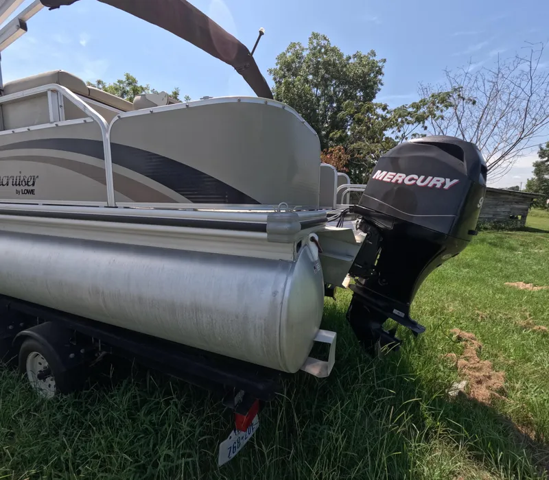 Slide: The Image of 2011 Lowe Suncruiser SF214 pontoon boat with Mercury outboard motor on grassy field. - 4