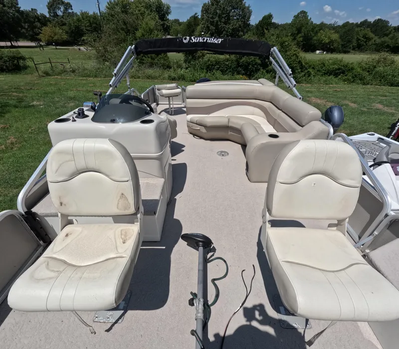 Slide: The Image of 2011 Lowe Suncruiser SF214 pontoon boat with beige seating and canopy, set in a grassy area. - 6