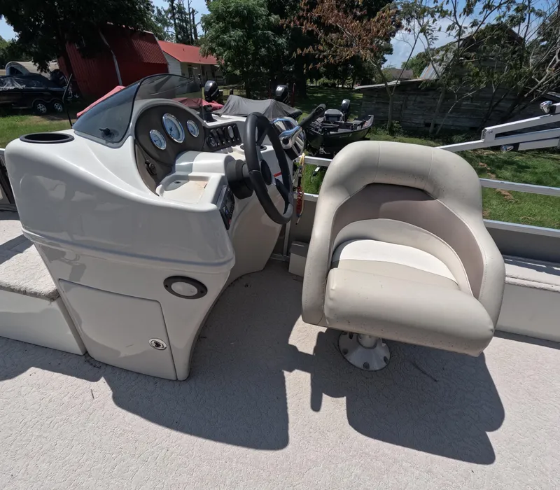 Slide: The Image of 2011 Lowe Suncruiser SF214 boat interior with steering console and cushioned seat. - 8