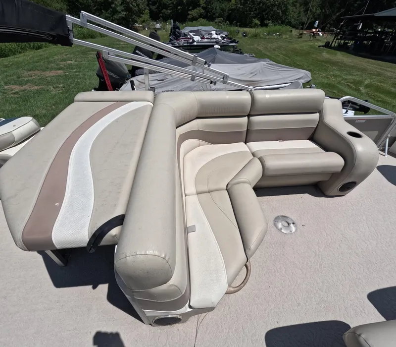 Slide: The Image of 2011 Lowe Suncruiser SF214 boat interior with beige seating and cup holders. - 9