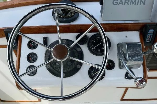 Slide: The Image of 1987 Duffy Flybridge Cruiser helm with steering wheel, gauges, and Garmin navigation system. - 13