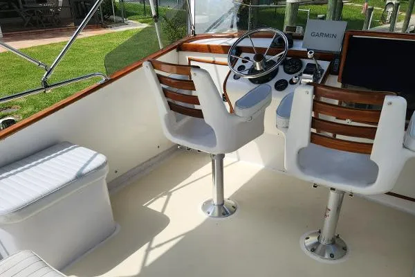 Slide: The Image of 1987 Duffy Flybridge Cruiser helm with dual seats, steering wheel, and Garmin navigation system. - 18