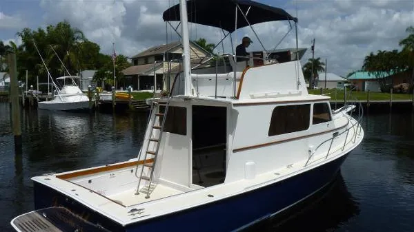 Slide: The Image of 1987 Duffy Flybridge Cruiser docked in a marina, featuring a sleek design and spacious deck. - 2