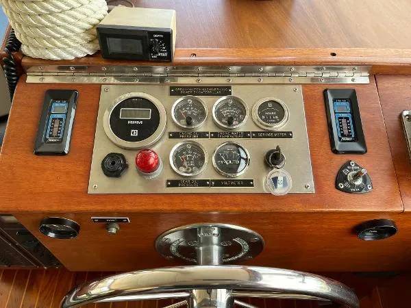 Slide: The Image of Control panel of a 1987 Duffy Flybridge Cruiser with gauges and steering wheel. - 21