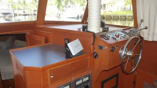 Slide: The Image of 1987 Duffy Flybridge Cruiser interior with wooden helm, steering wheel, and control panel. - 23