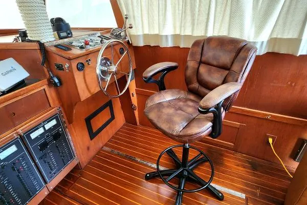 Slide: The Image of 1987 Duffy Flybridge Cruiser helm with leather chair and wooden interior. - 24