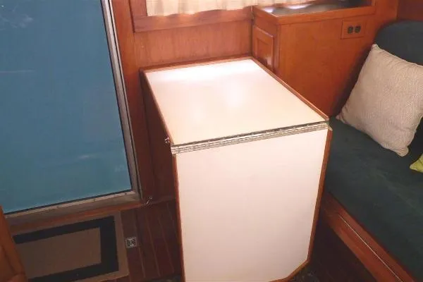 Slide: The Image of 1987 Duffy Flybridge Cruiser interior with compact white refrigerator and wooden cabinetry. - 32