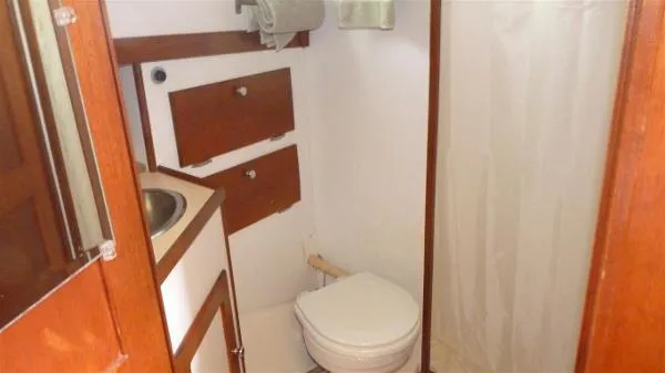 Slide: The Image of 1987 Duffy Flybridge Cruiser bathroom with sink, toilet, and wooden cabinets. - 34