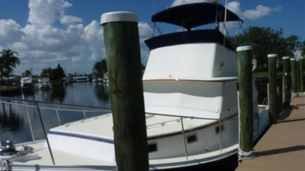 Slide: The Image of 1987 Duffy Flybridge Cruiser docked by a scenic waterfront. - 4