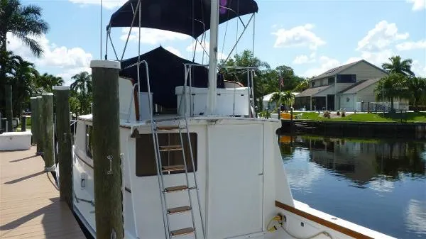 Slide: The Image of 1987 Duffy Flybridge Cruiser docked by a scenic waterfront with palm trees. - 5