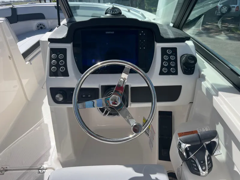 Slide: The Image of 2025 Robalo R257 Dual Console boat dashboard with steering wheel and control panel. - 12