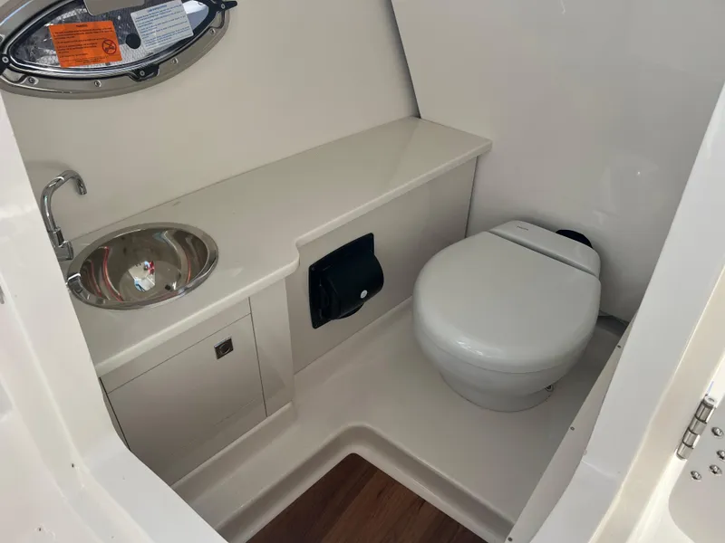 Slide: The Image of 2025 Robalo R257 Dual Console boat interior with sink and toilet. - 15