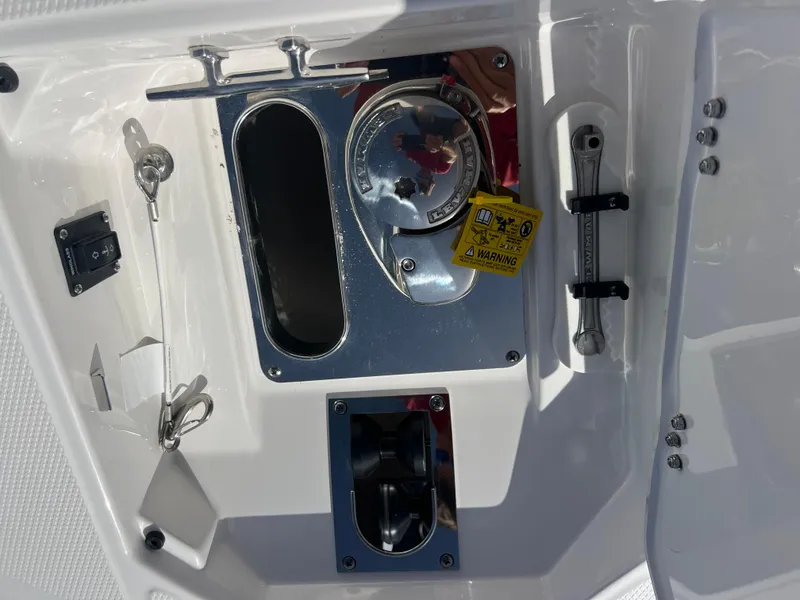 Slide: The Image of 2025 Robalo R257 Dual Console boat control panel with warning label and tools. - 17