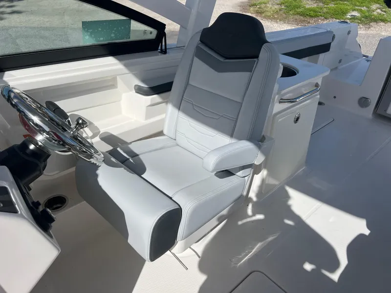 Slide: The Image of 2025 Robalo R257 Dual Console boat interior with sleek captain's chair and steering wheel. - 20
