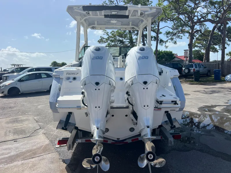 Slide: The Image of 2025 Robalo R257 Dual Console boat with twin 200 horsepower engines, parked outdoors. - 4