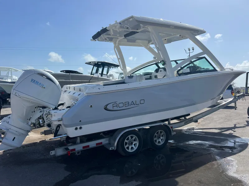 Slide: The Image of 2025 Robalo R257 Dual Console boat on trailer under clear sky. - 5