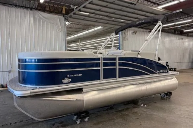 Slide: The Image of 2025 Harris CR190 pontoon boat in a warehouse, featuring a sleek blue and silver design. - 11