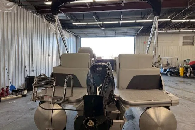 Slide: The Image of 2025 Harris CR190 pontoon boat in a warehouse, rear view with motor and ladder. - 5