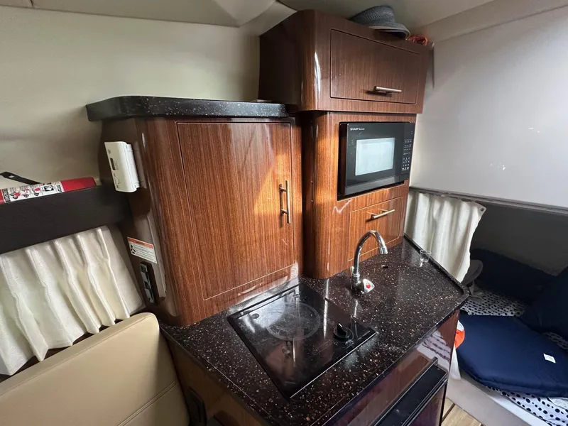 Slide: The Image of 2013 Regal 28 Express boat interior with kitchenette, microwave, and sink. - 10
