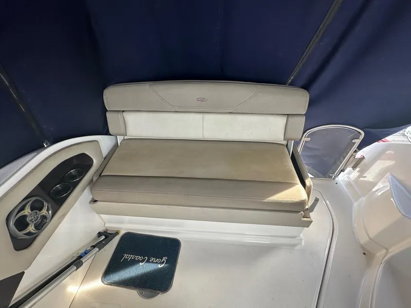 Slide: The Image of 2013 Regal 28 Express boat interior with cushioned seating and cup holders. - 6