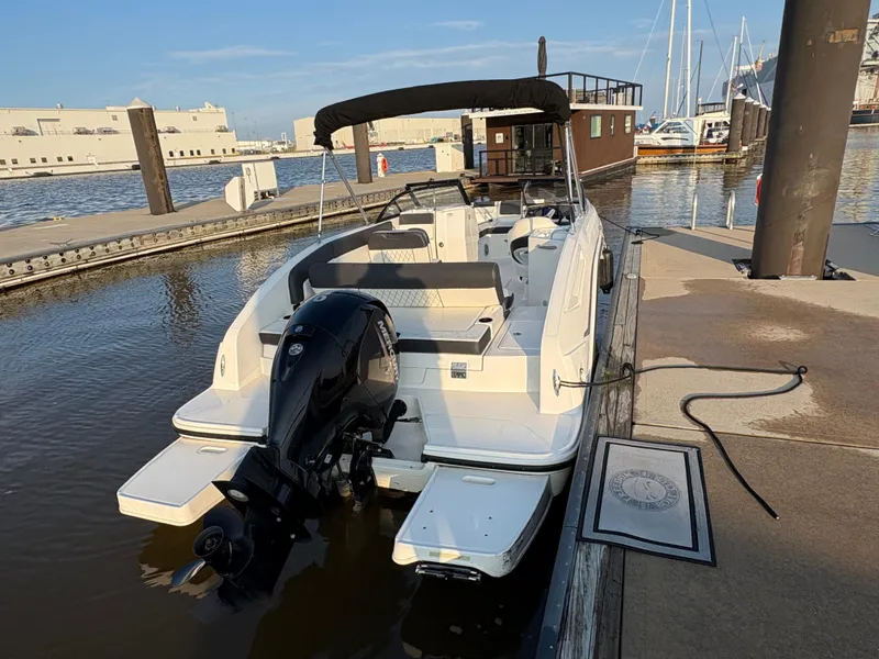 Slide: The Image of 2022 Bayliner DX 2200 boat docked at marina with outboard motor. - 3