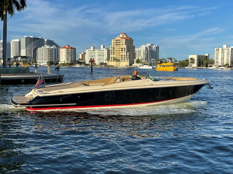 The Image of 2015 Chris-Craft 32 Launch boat cruising in urban waterfront setting. - 1