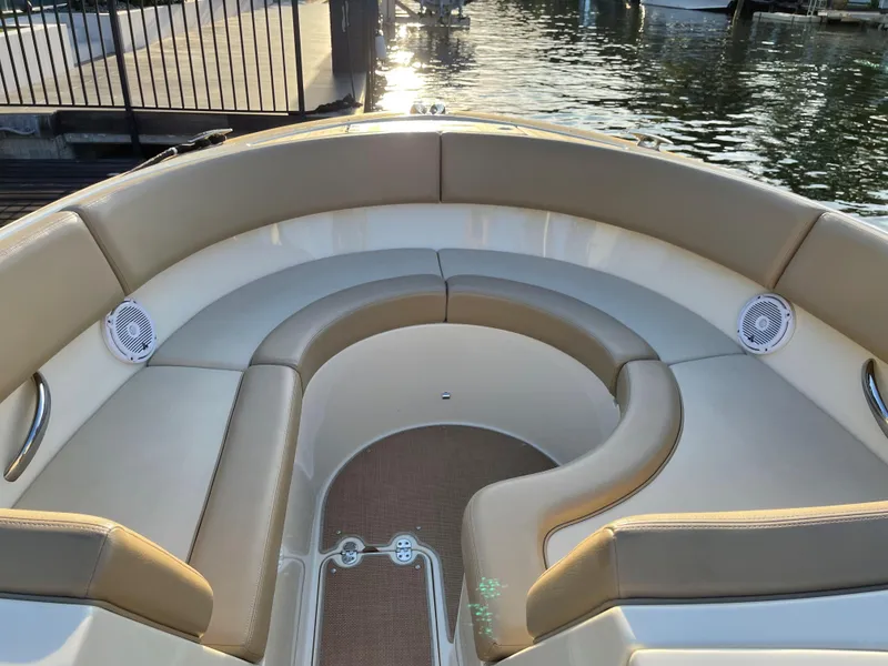 Slide: The Image of 2015 Chris-Craft 32 Launch boat interior with beige seating and waterfront view. - 12