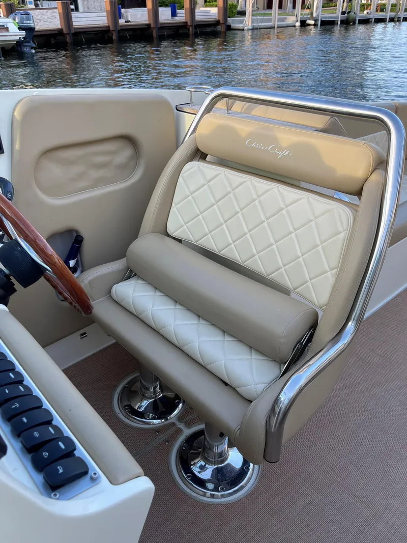 Slide: The Image of Luxurious seating on a 2015 Chris-Craft 32 Launch boat, featuring elegant diamond-pattern upholstery. - 17