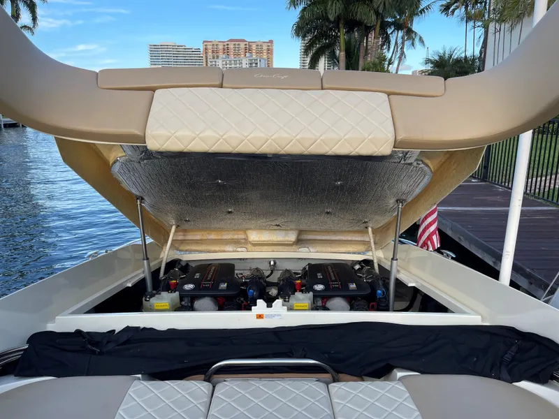 Slide: The Image of 2015 Chris-Craft 32 Launch boat engine compartment open, docked by water, palm trees in background. - 24