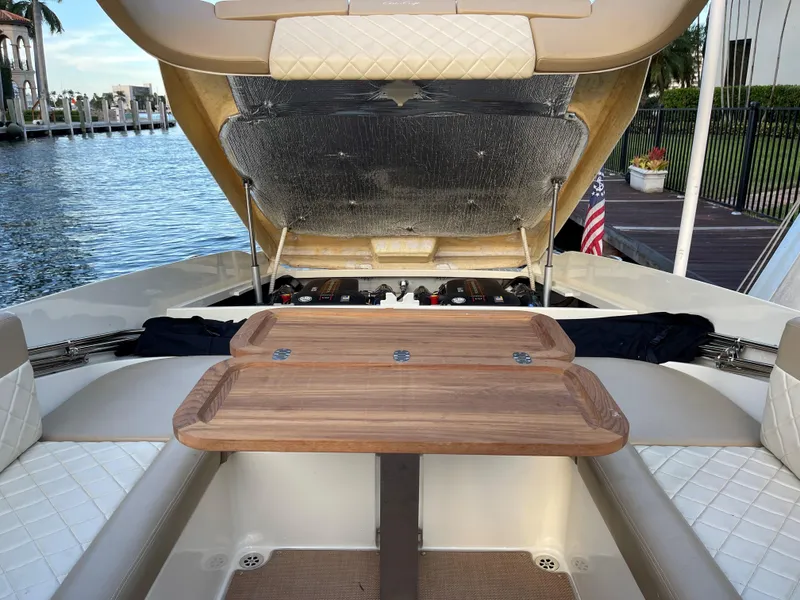 Slide: The Image of 2015 Chris-Craft 32 Launch boat interior with open engine hatch and wooden table. - 25