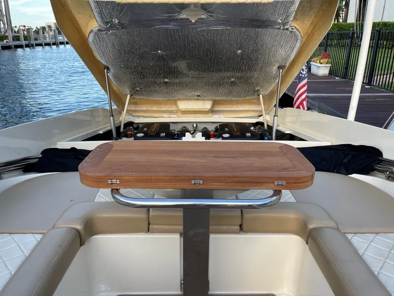Slide: The Image of 2015 Chris-Craft 32 Launch boat with open engine compartment and wooden table. - 26