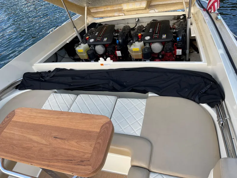 Slide: The Image of 2015 Chris-Craft 32 Launch boat engine compartment with seating and wooden table. - 32
