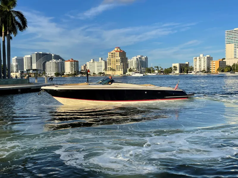 Slide: The Image of 2015 Chris-Craft 32 Launch boat cruising near city skyline on a sunny day. - 4